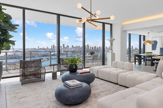 Luxury Home Staging Before-After -Modern living room with large windows offering a cityscape view.