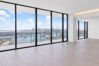 Luxury Home Staging Before-After -Modern interior with large glass windows offering a view of a cityscape.