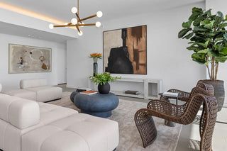Luxury Home Staging Before-After -Modern living room with white sofa, wicker chairs, and decorative elements.