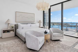 Luxury Home Staging Before-After -Modern bedroom with gray furniture and a large window view.