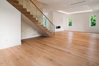 Luxury Home Staging Before-After -Modern interior with wooden floor, staircase, and large windows.