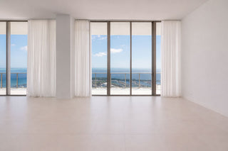 Luxury Home Staging Before-After -Modern room with large windows offering a view of the ocean.
