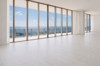 Luxury Home Staging Before-After -Modern interior with large glass windows offering a view of the ocean.