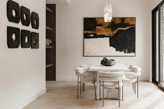 Turnkey Furniture Packages for purchase. Modern dining room with a round table and chairs, abstract art on the wall, and large windows. All About the Wow