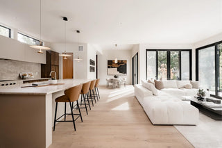 Turnkey Furniture Rental Miami. Modern living room with white sofa, kitchen island, and large windows.
