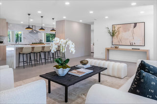 Turnkey Furniture Rental Miami. Modern living room with white furniture, a black coffee table, and decorative elements.